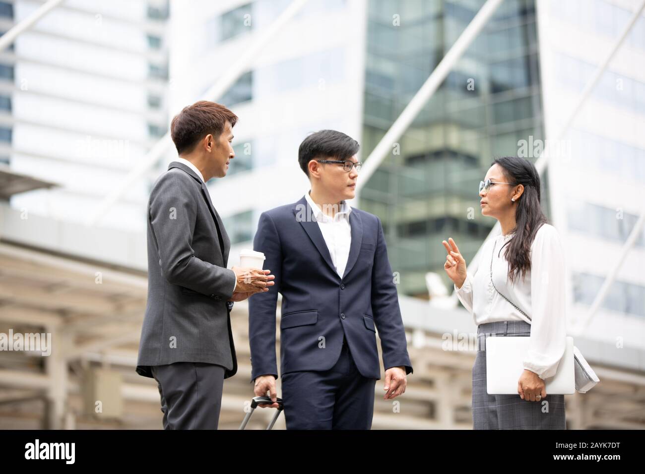 Gruppo di uomini d'affari che si levano in piedi con l'agitazione della mano sull'accordo di affari o sul lavoro di squadra contro la costruzione Foto Stock