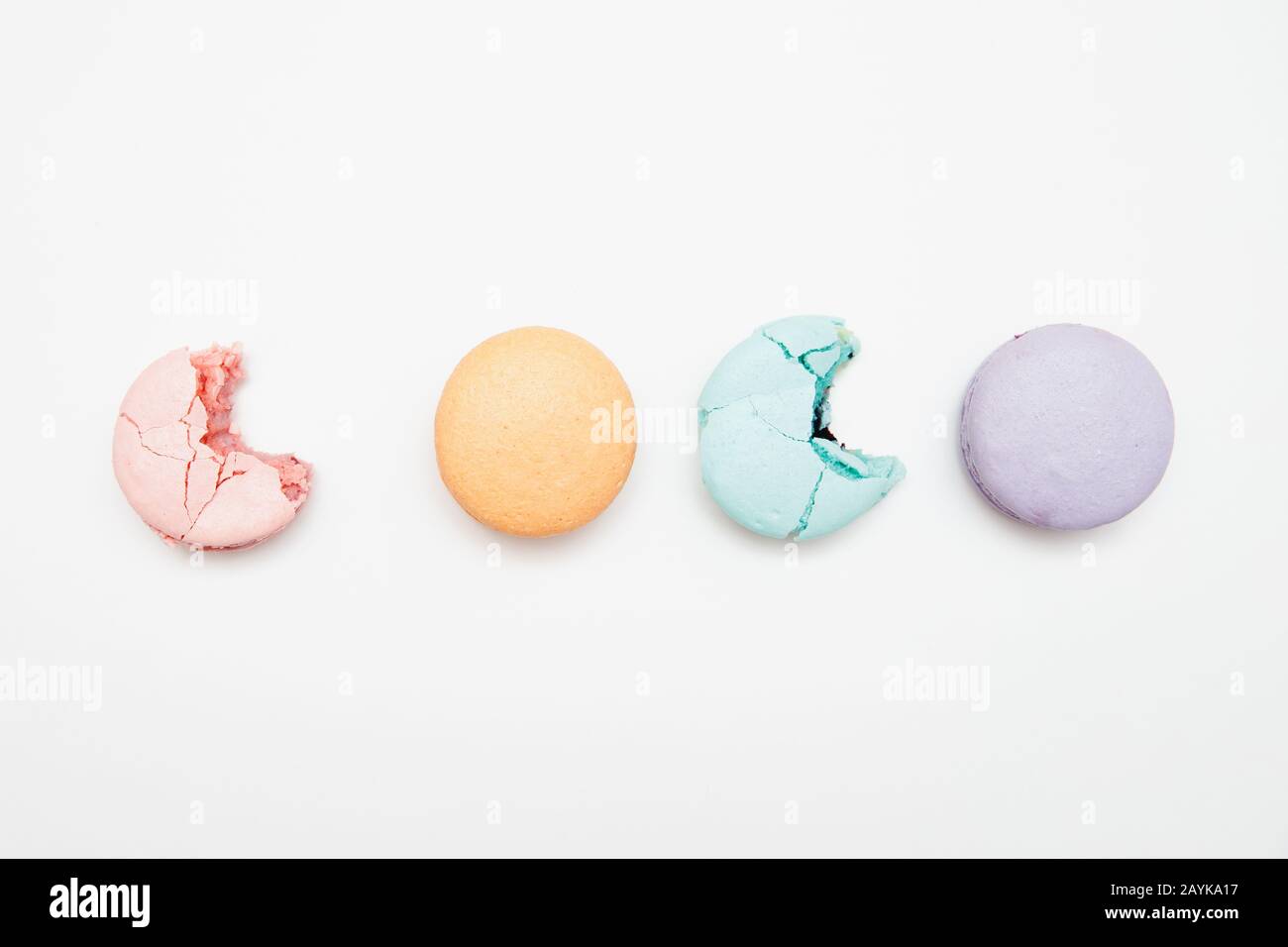 Turchese colorato, rosa, arancio, torta viola macaron francese o amaretto bitten su sfondo bianco Foto Stock