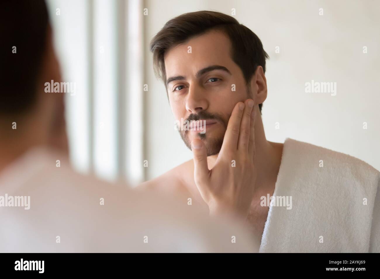 L'uomo caucasico fa la procedura di skincare nel bagno domestico Foto Stock