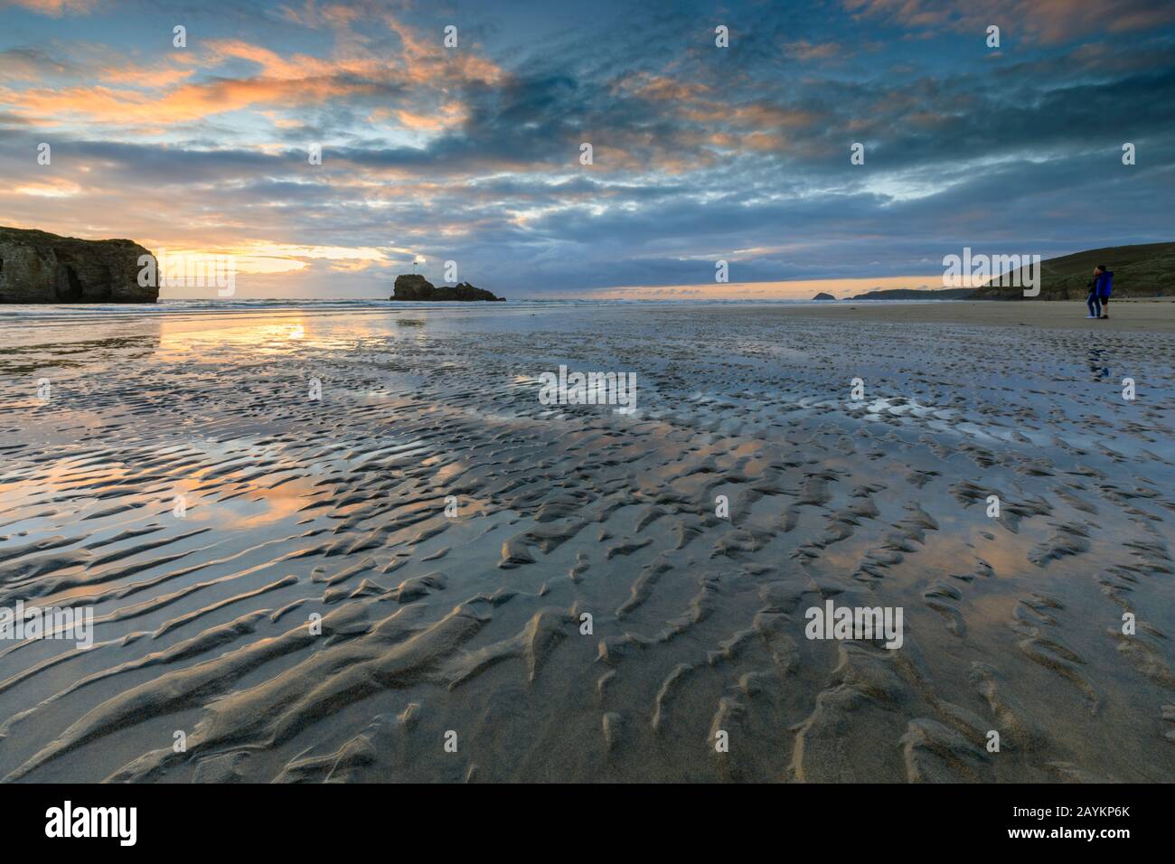 La gente guarda il tramonto sulla spiaggia di Perranporth in Cornovaglia. Foto Stock