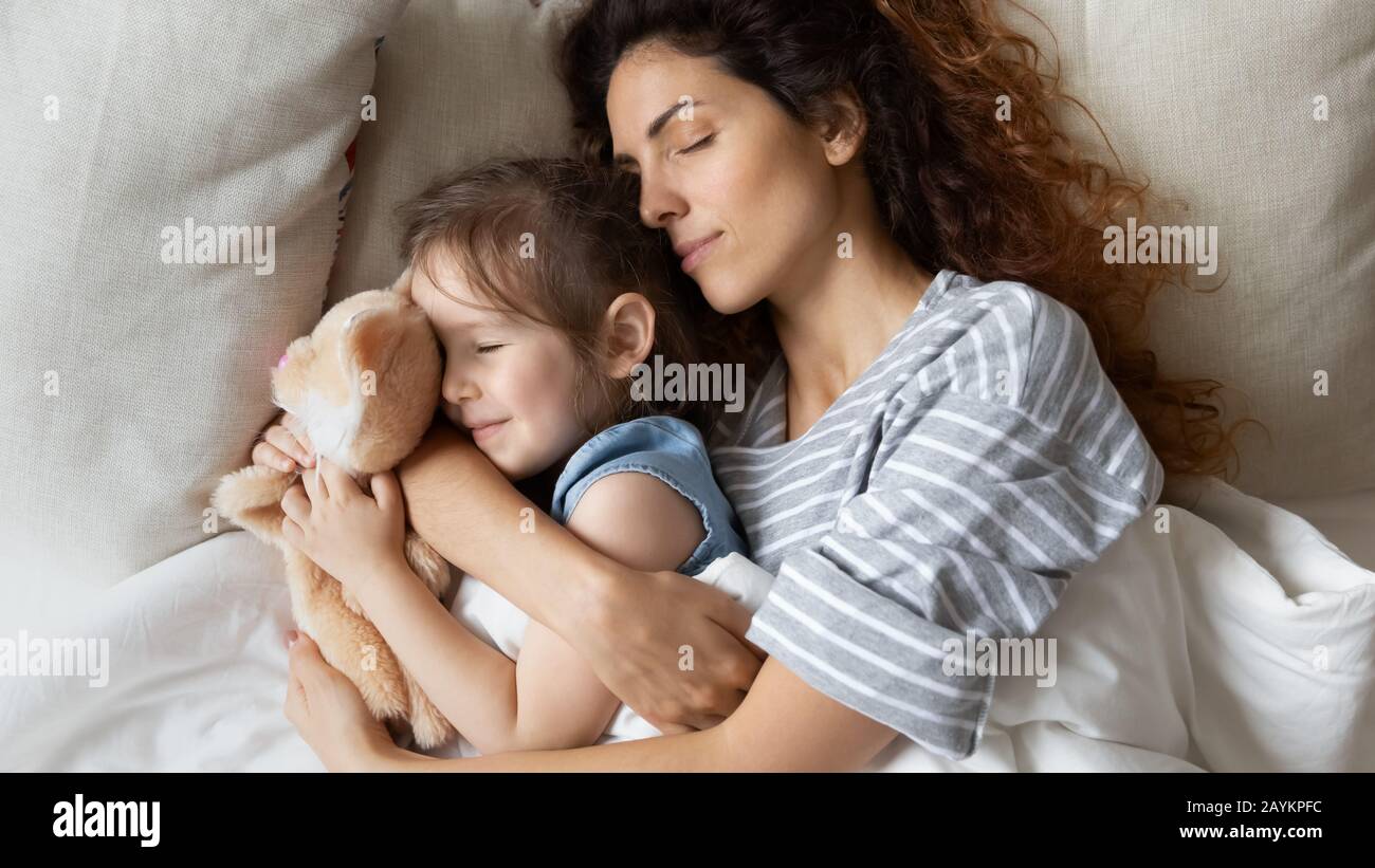 Tranquilla madre giovane dormire con calma piccola figlia. Foto Stock