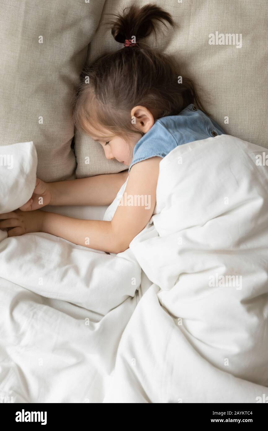 Un bambino tranquillo e felice riposato da solo in un comodo letto. Foto Stock