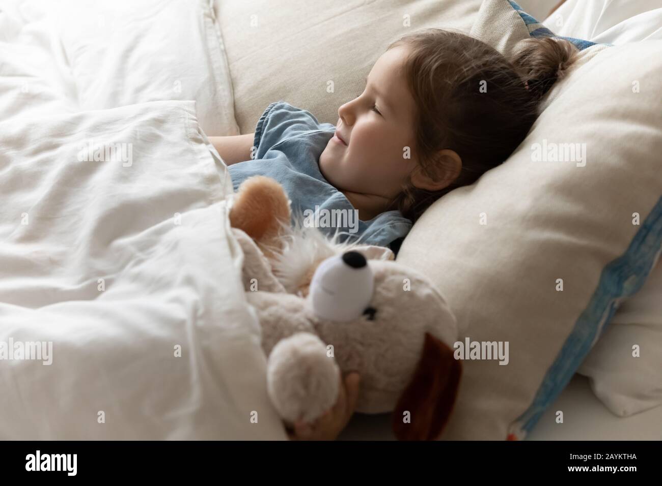 Mia figlia piccola e felice dorme a letto. Foto Stock