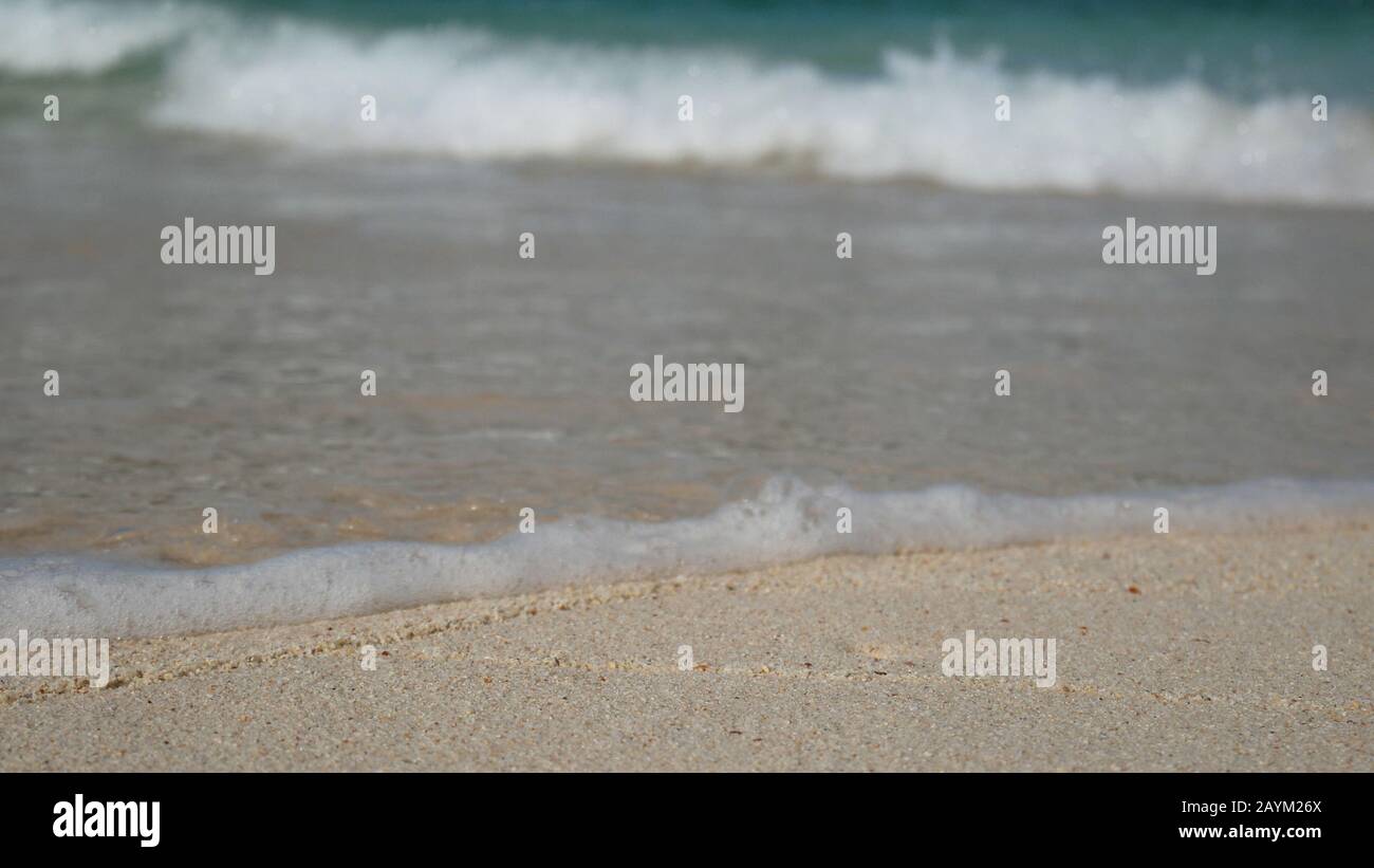 spiaggia estiva e mare vacanza sfondo carta da parati. spiaggia di sabbia bianca e acqua limpida con bolla d'onda bianca Foto Stock