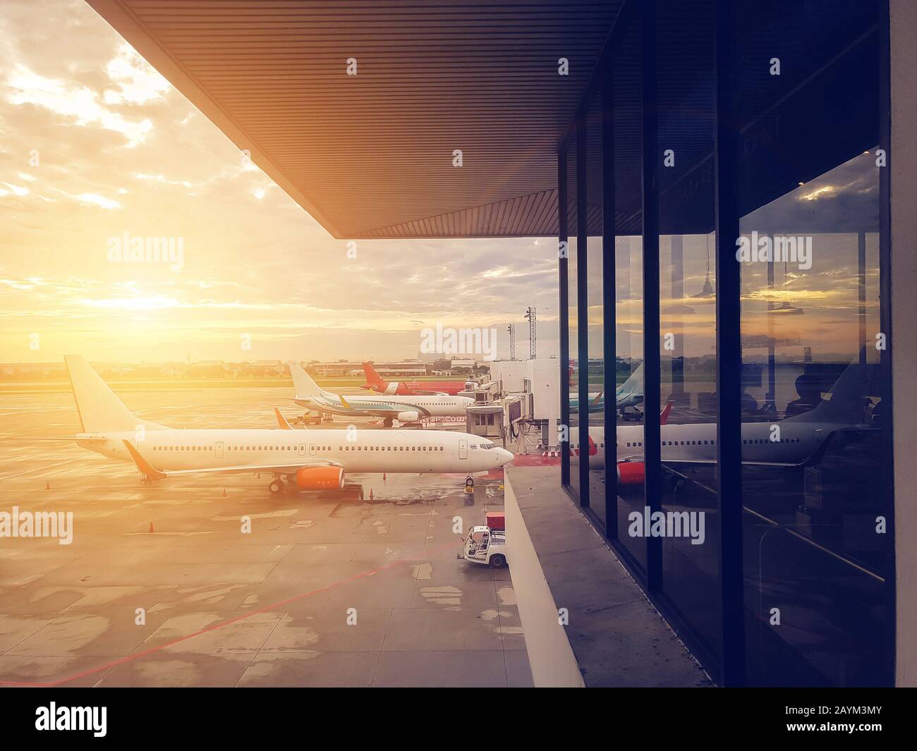 aereo alla porta del terminal dell'aeroporto, moderno aeroporto internazionale al tramonto. trasporto in aereo e concetto di viaggio Foto Stock