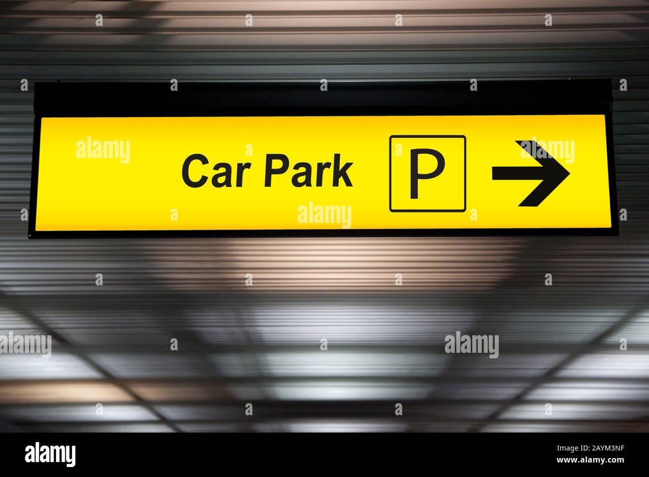 cartello giallo con la freccia che indica la zona parcheggio presso il terminal dell'aeroporto Foto Stock