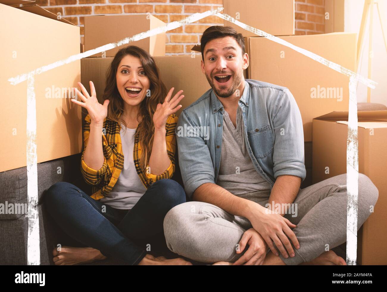La coppia felice ha trovato una nuova casa e hanno bisogno di organizzare tutti i pacchetti. Concetto di successo, cambiamento, positività e futuro Foto Stock