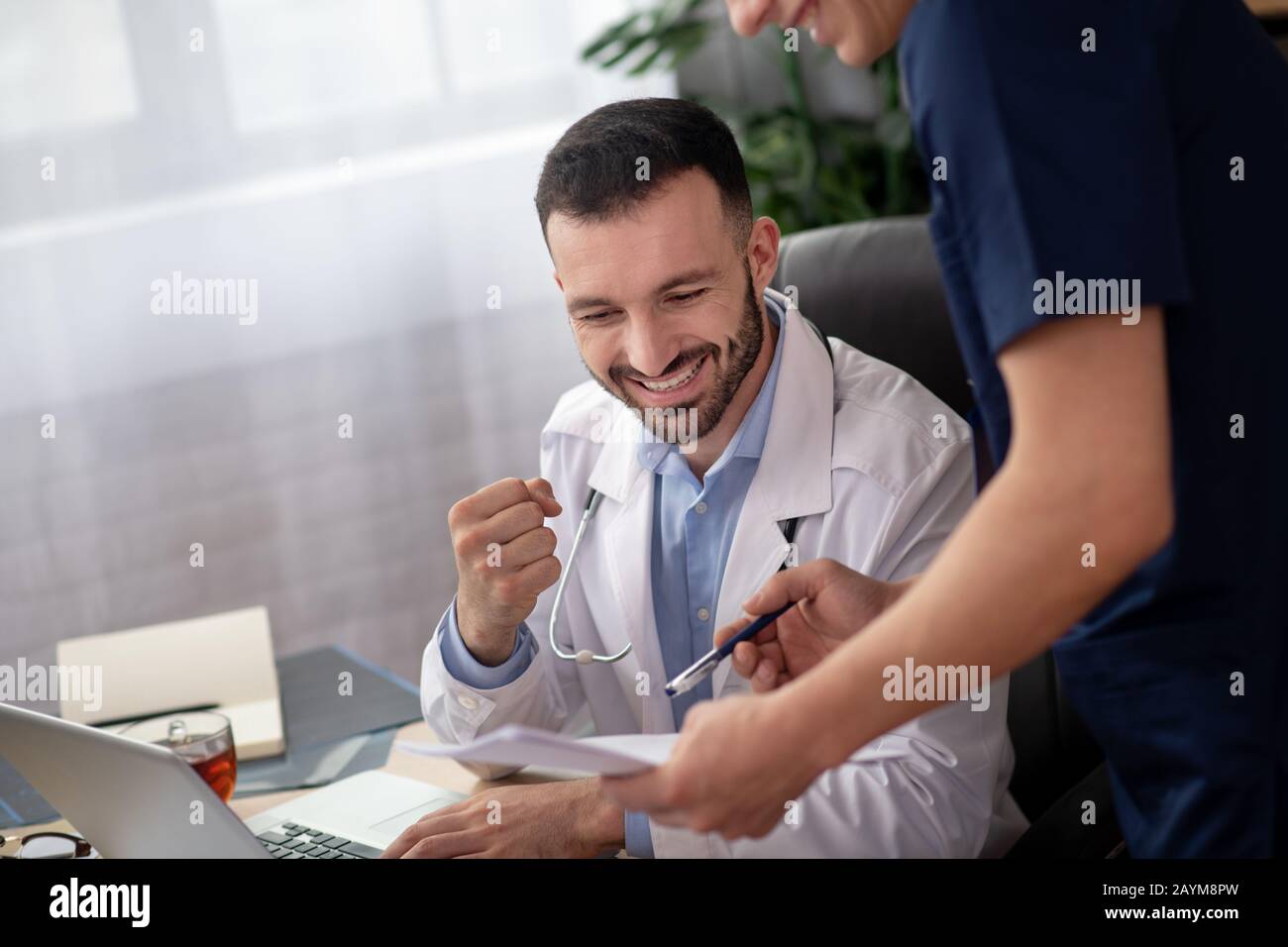 Bearded medico di testa sorridente mentre parla con il suo collega Foto Stock