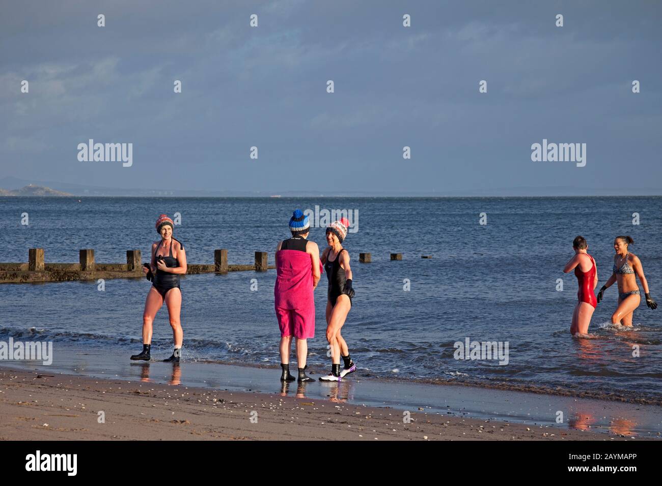 Portobello Beach, Edimburgo, Scozia, Regno Unito. 16th feb.2020. Sole e temperatura di 4 gradi vento gusting a 65kph, ma più di 30 nuotatori selvaggi di tutte le età, forme e dimensioni con costumi o muta goduto il primo mattino bracing tuffo nel Firth of Forth. Foto Stock