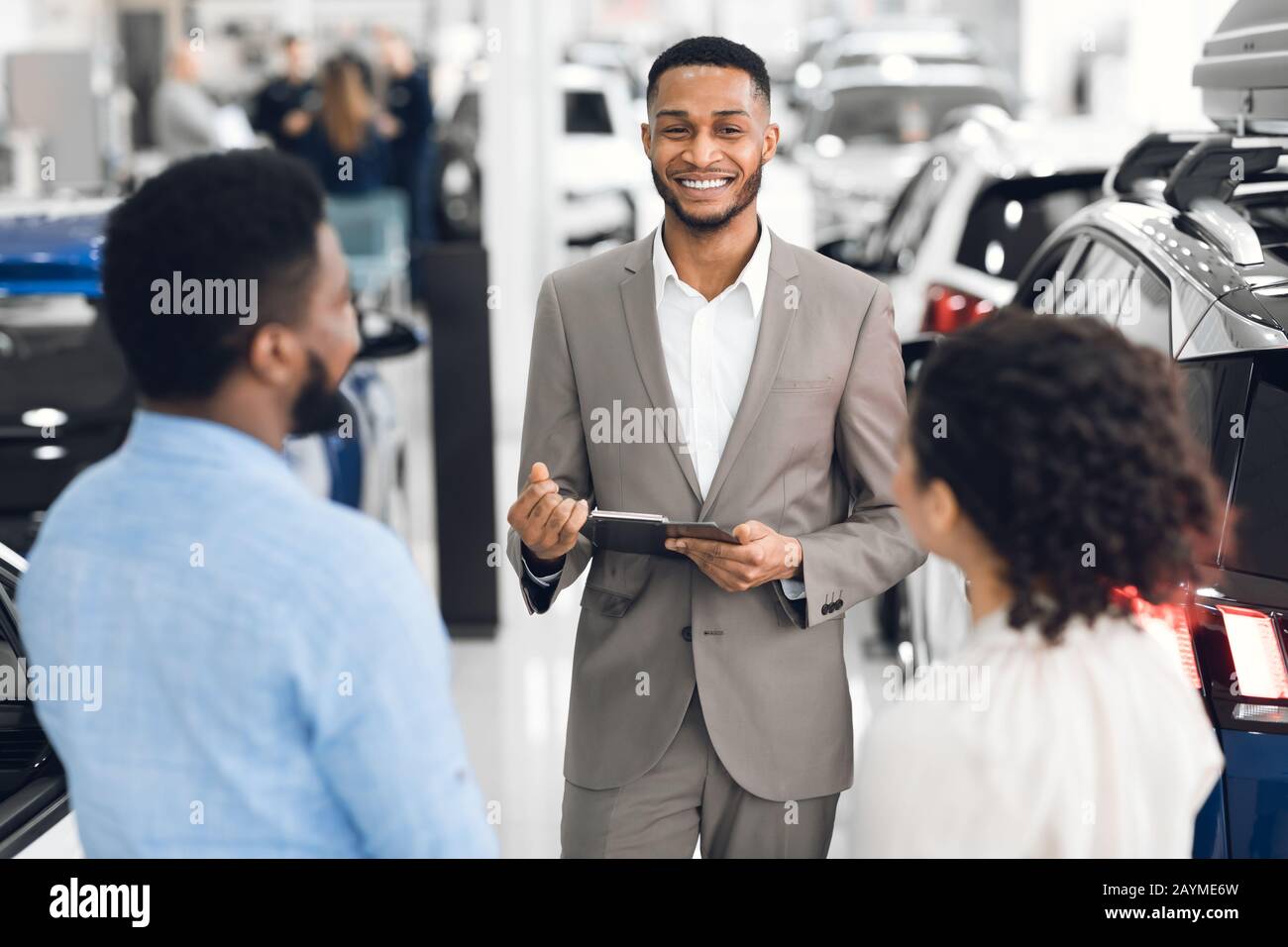 Concessionario Di Auto Che Parla Con I Clienti Che Vende Automobili Nel Dealership Store Foto Stock