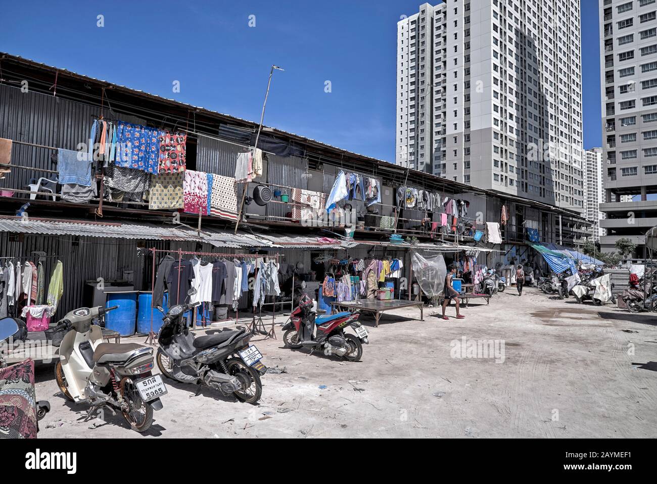 Alto e moderno condominio che contrasta con vecchio stile di stagno Shack economia alloggiamento dando il concetto di nuovo v vecchio. Thailandia Sud-Est Asiatico Foto Stock