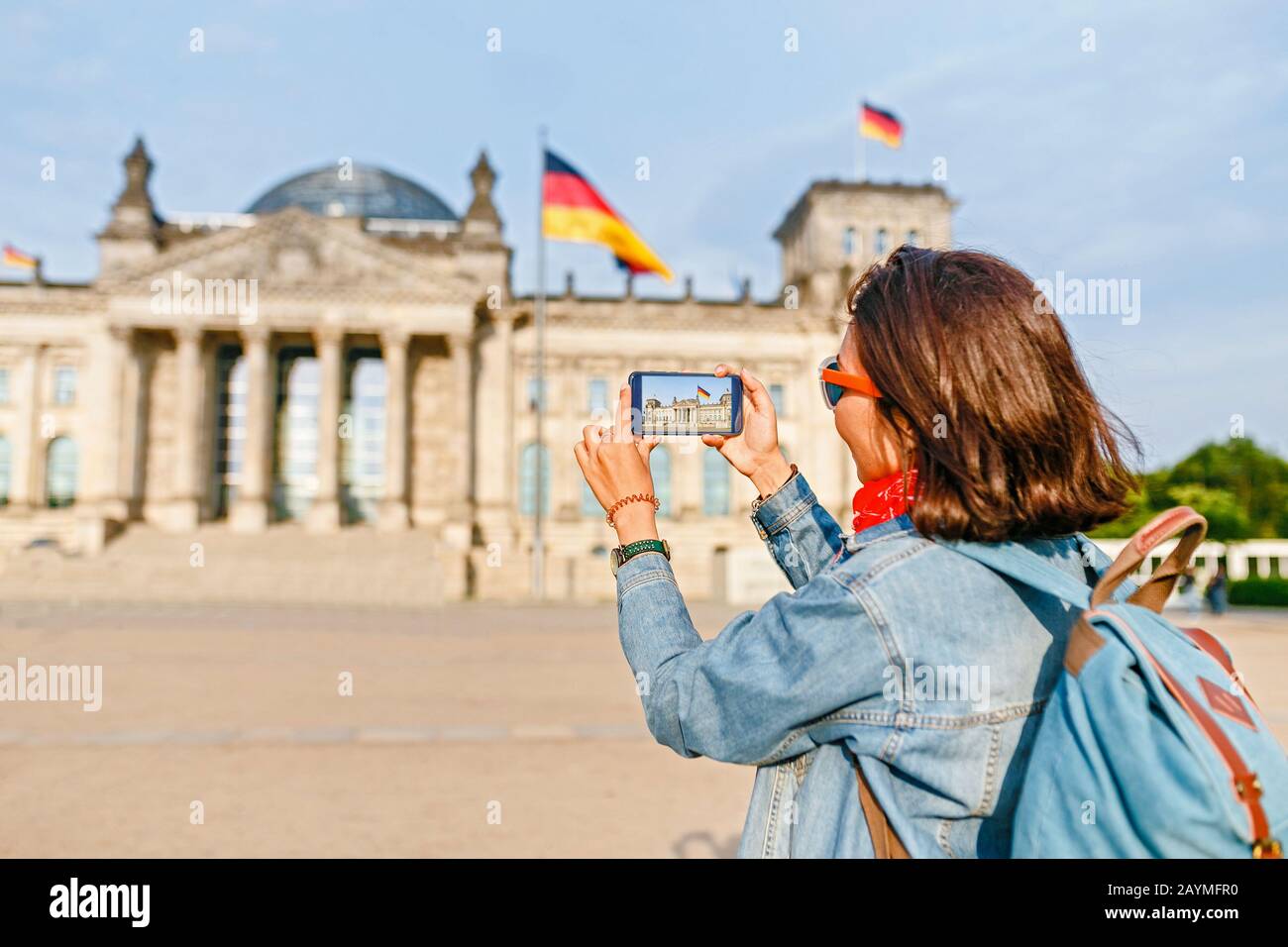 Bella giovane donna in abbigliamento casual scattare foto dal suo telefono cellulare al Bundestag, Berlino Foto Stock