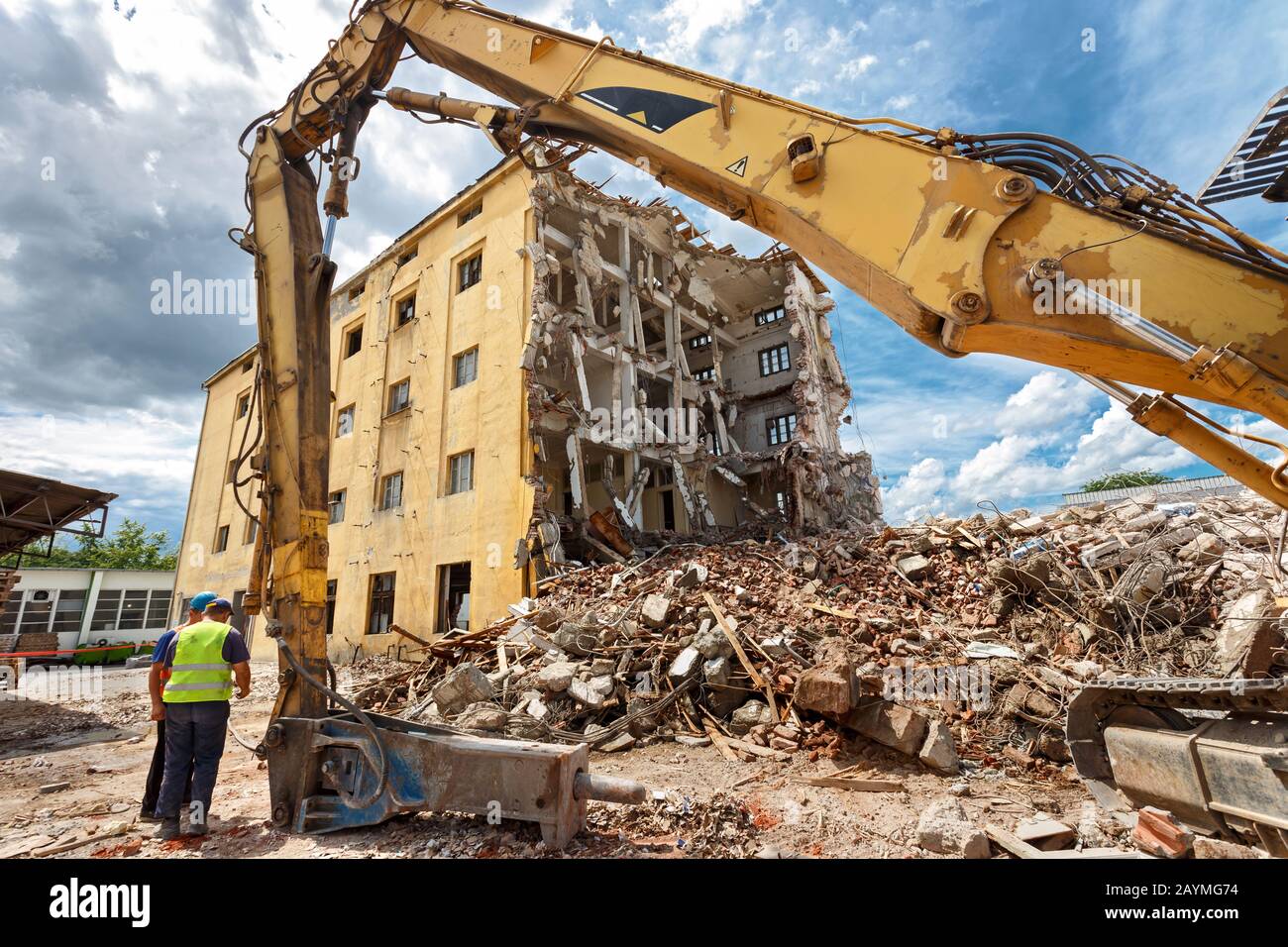 Rovine di edificio demolito. Macchinari pesanti circondati da rovine. Concetto di industria edile. Foto Stock