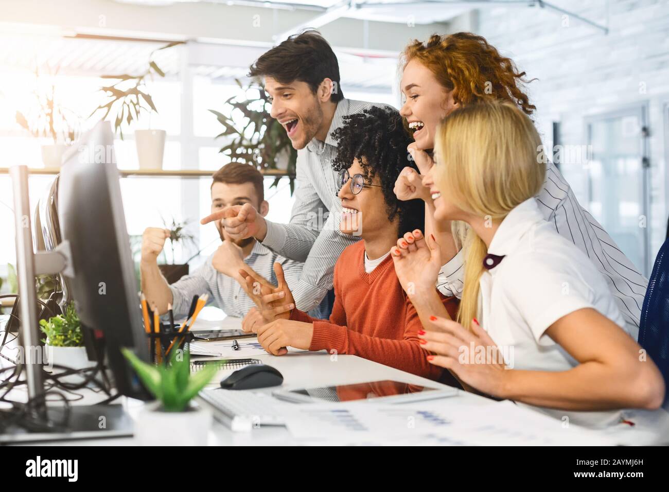 Giovane team che guarda lo schermo del notebook, lavorando sul progetto Foto Stock