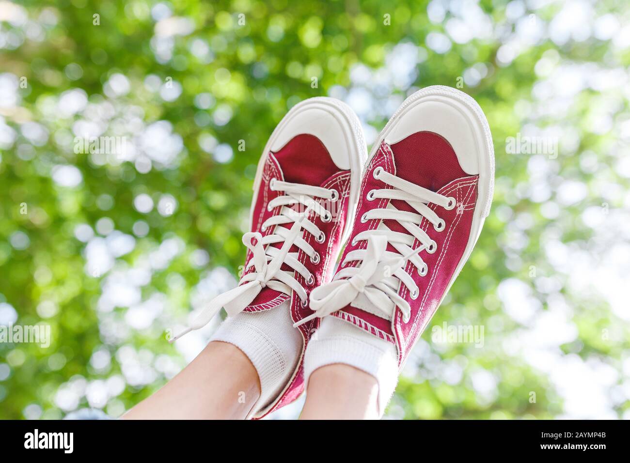 Un piede in scarpe da ginnastica su uno sfondo di albero prk, il concetto di  moda e gambe senza varicose Foto stock - Alamy