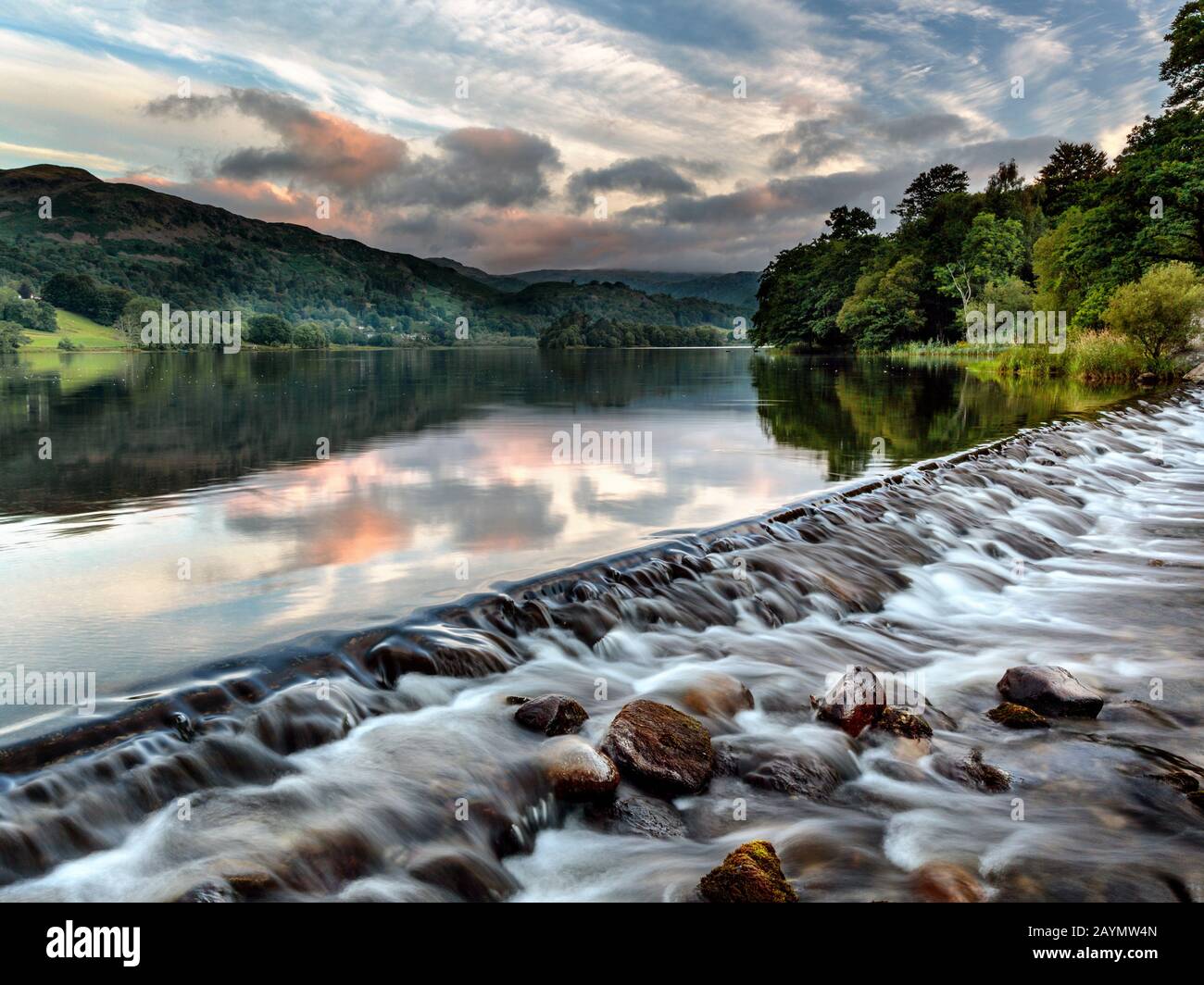 L'acqua che scorre sopra lo stramazzo al Lago di Grasmere. Il fiume Rothay lascia il lago Grasmere verso Rydal. Lake District, Cumbria, Inghilterra, Regno Unito Foto Stock