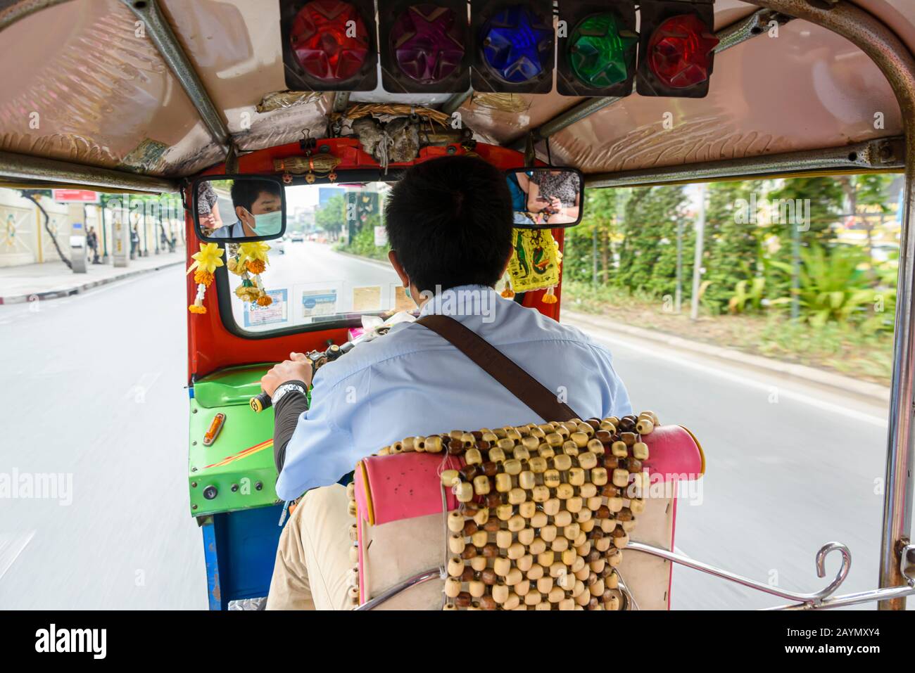 Un pilota tuk-tuk indossa una maschera facciale per proteggerlo contro Coronavirus COVID-19 mentre guida per le strade di Bangkok, Thailandia. Foto Stock