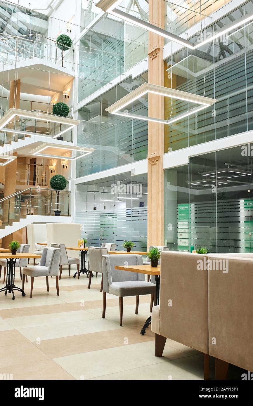design open office. elegante sala da ufficio con scrivanie e sedie mobili, scatto verticale. creazione di un ambiente di lavoro unico Foto Stock