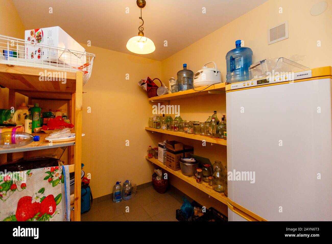 Deposito nel cottage. Conservazione. Ripiani con numerose lattine e bottiglie, frigorifero. Foto Stock