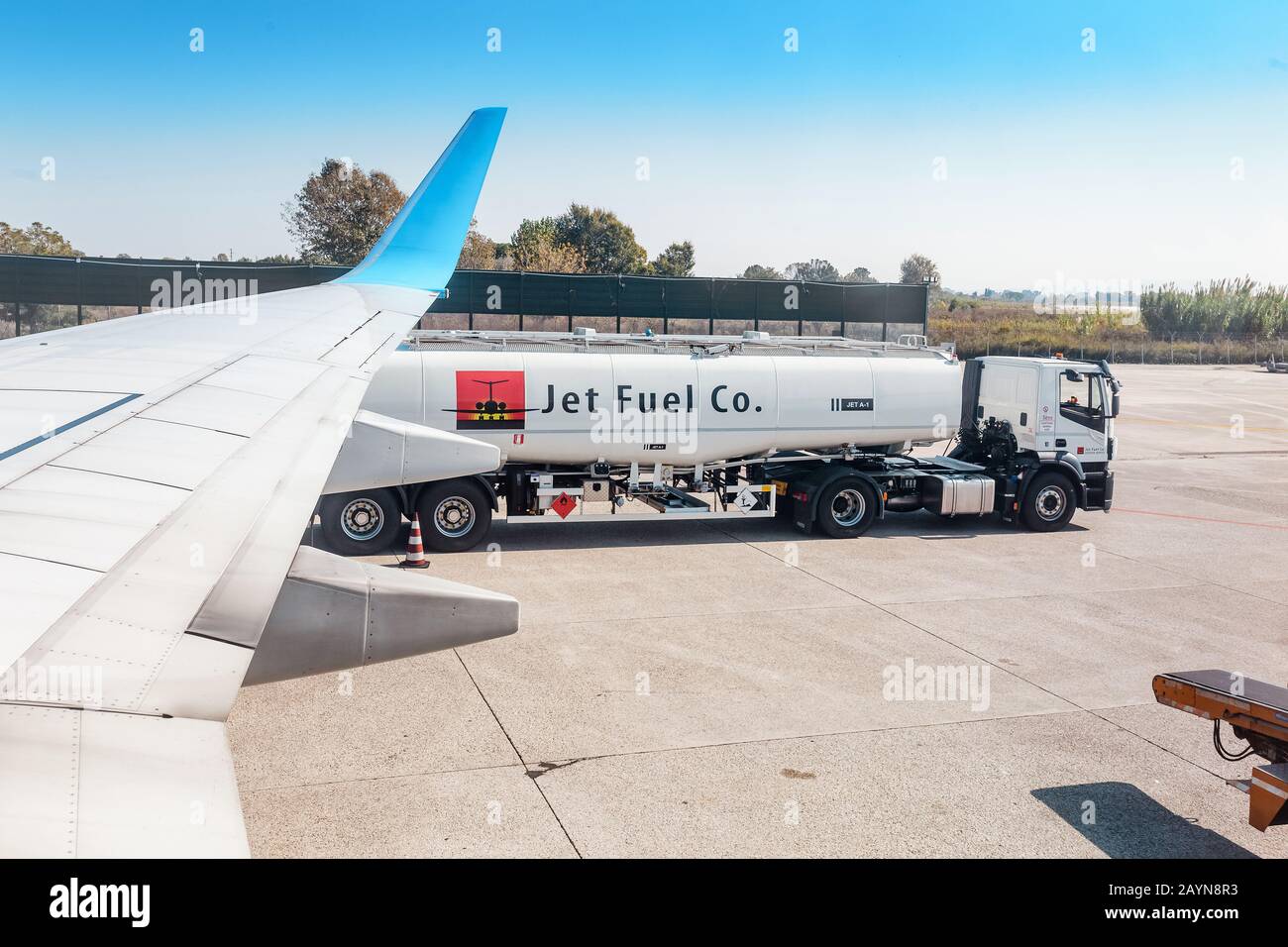 Pisa, ITALIA - 14 ottobre 2018: Camion del cherosene carburante vicino all'aereo sulla pista dell'aeroporto Foto Stock