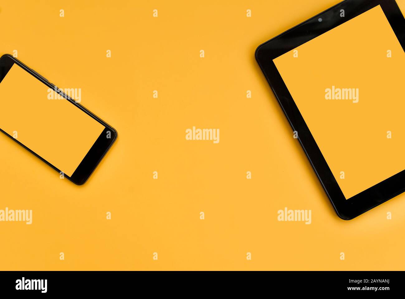 Tablet nero e telefono nero su sfondo arancione. Inserire il testo. Vista dall'alto. Disposizione piatta Foto Stock