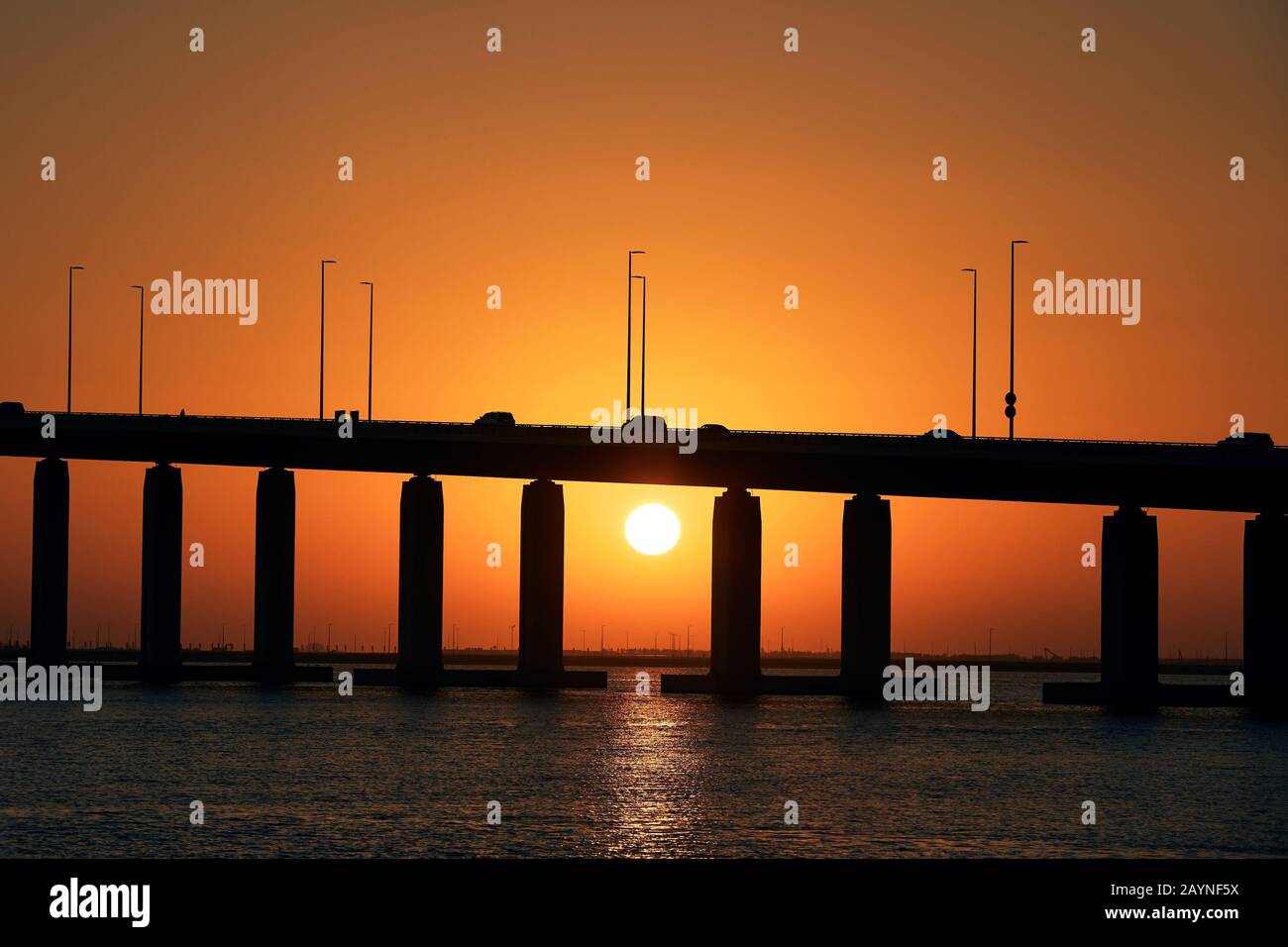 Silhouette di ponte sul mare contro il bel tramonto. Abu Dhabi, Emirati Arabi Uniti Foto Stock