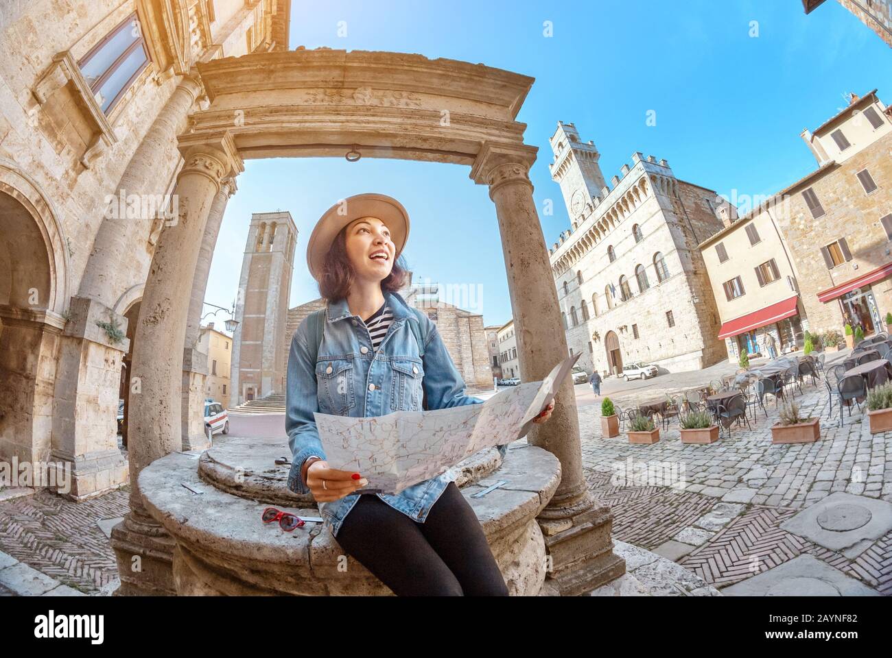 Felice turista asiatico con mappa persa nel centro storico di Montepulciano, Toscana. Vacanze e viaggi in Italia concetto Foto Stock