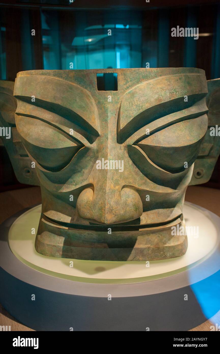 Una maschera in bronzo del 12th secolo a.C. nella mostra di antichi manufatti al Museo Sanxingdui di Sanxingdui vicino a Chengdu, provincia di Sichuan a CH Foto Stock