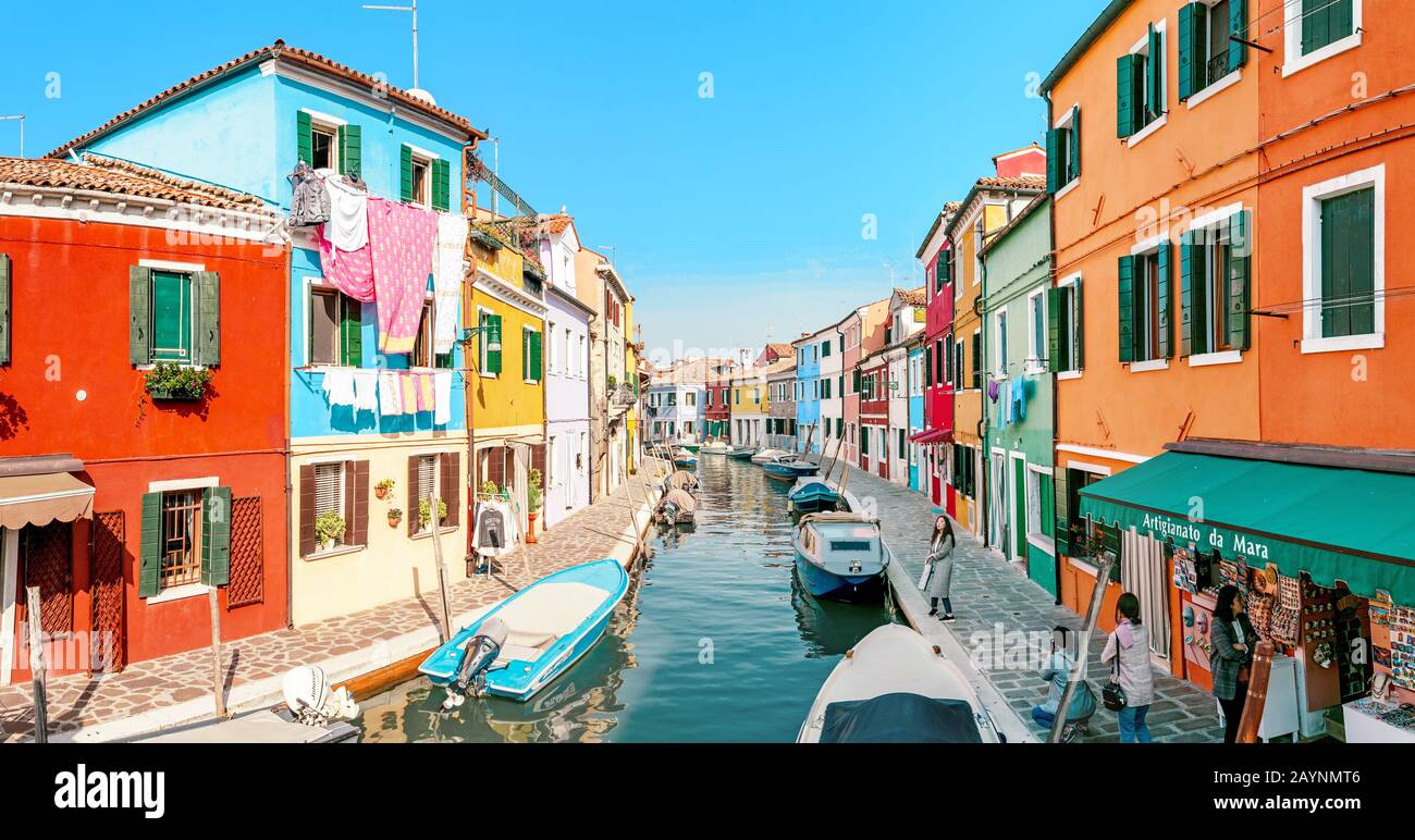 24 OTTOBRE 2018, BURANO, VENEZIA, ITALIA: Paesaggio urbano colorato con canali e persone nell'isola di Burano nella regione di Venezia, famosa destinazione turistica Foto Stock