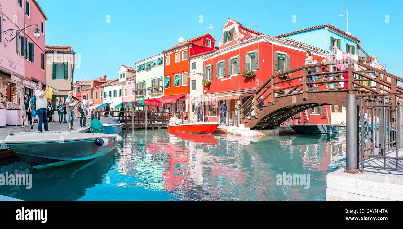24 OTTOBRE 2018, BURANO, VENEZIA, ITALIA: Paesaggio urbano colorato con canali e persone nell'isola di Burano nella regione di Venezia, famosa destinazione turistica Foto Stock