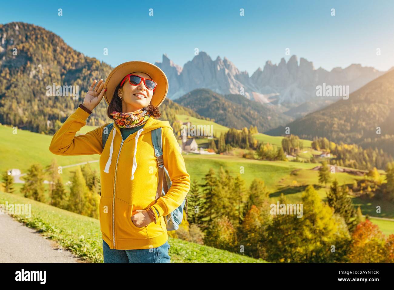 Felice giovane donna viaggio nel villaggio di Magdalena in montagna Dolomiti, Italia in autunno Foto Stock