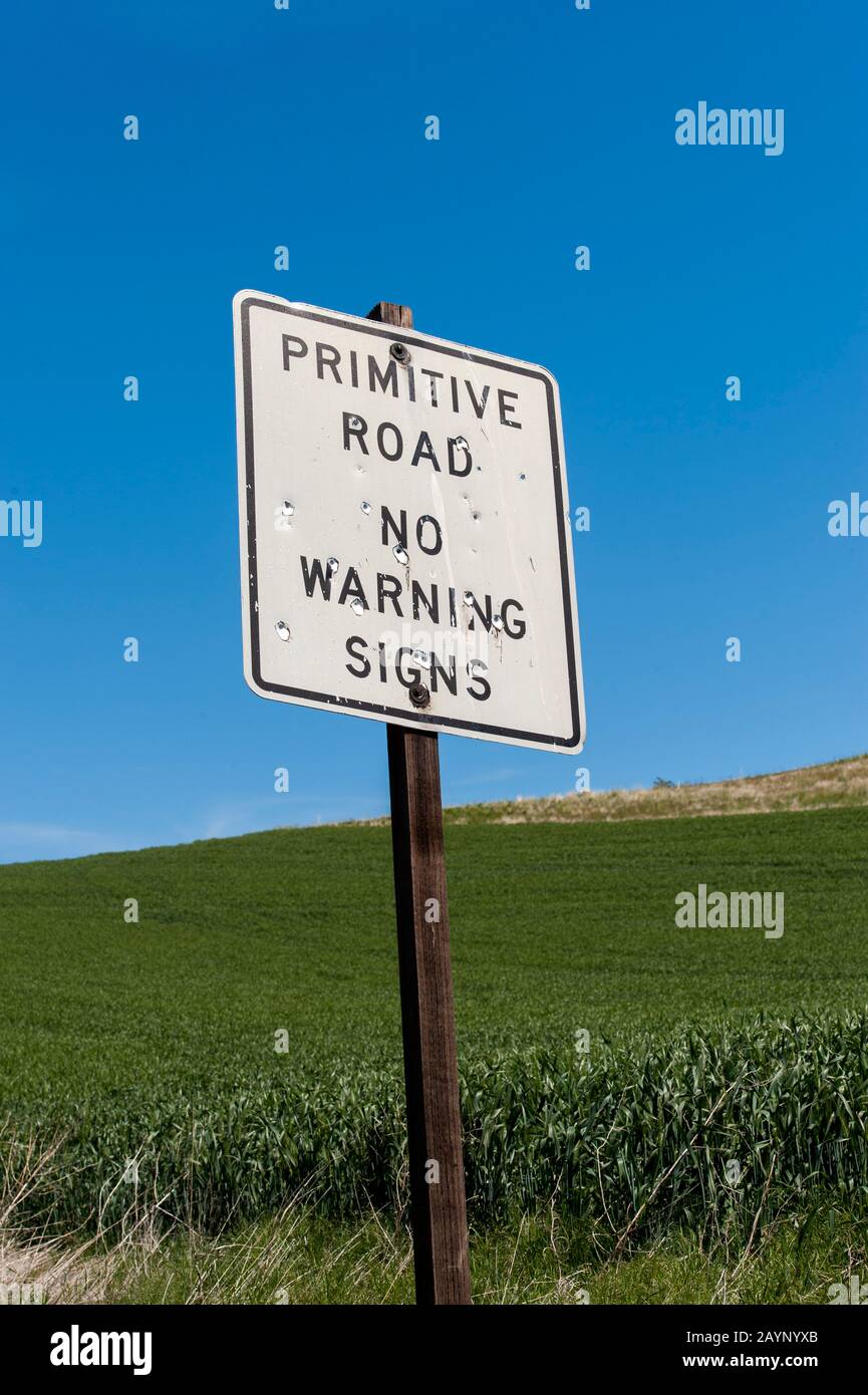 Cartello stradale primitivo con buchi di pallottole nel Palouse vicino al Pullman, Eastern Washington state, USA. Foto Stock