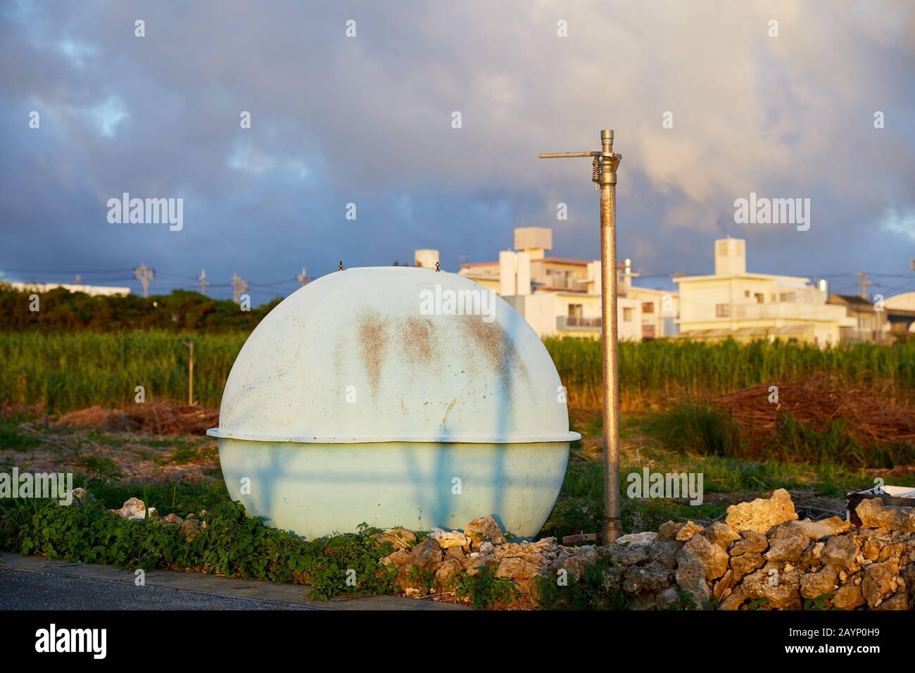 Serbatoio d'acqua sferico azzurro a lato di una strada, la sera presto; Namihira, Yomitan, Okinawa, Giappone Foto Stock
