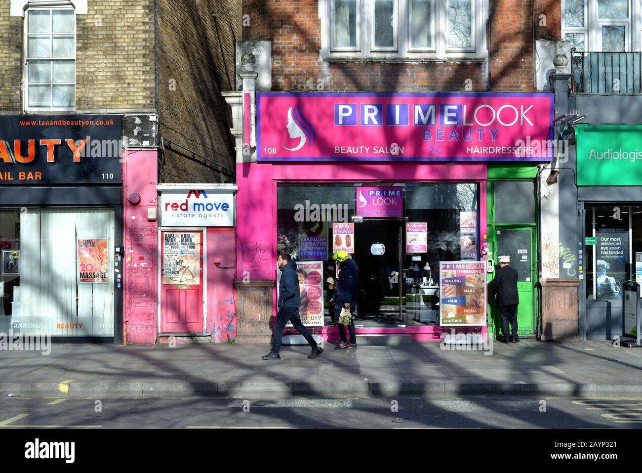 La facciata colorata di un Negozio Di Parrucchieri indipendente chiamato Primelook, a Shepherds Bush Londra Inghilterra Regno Unito Foto Stock