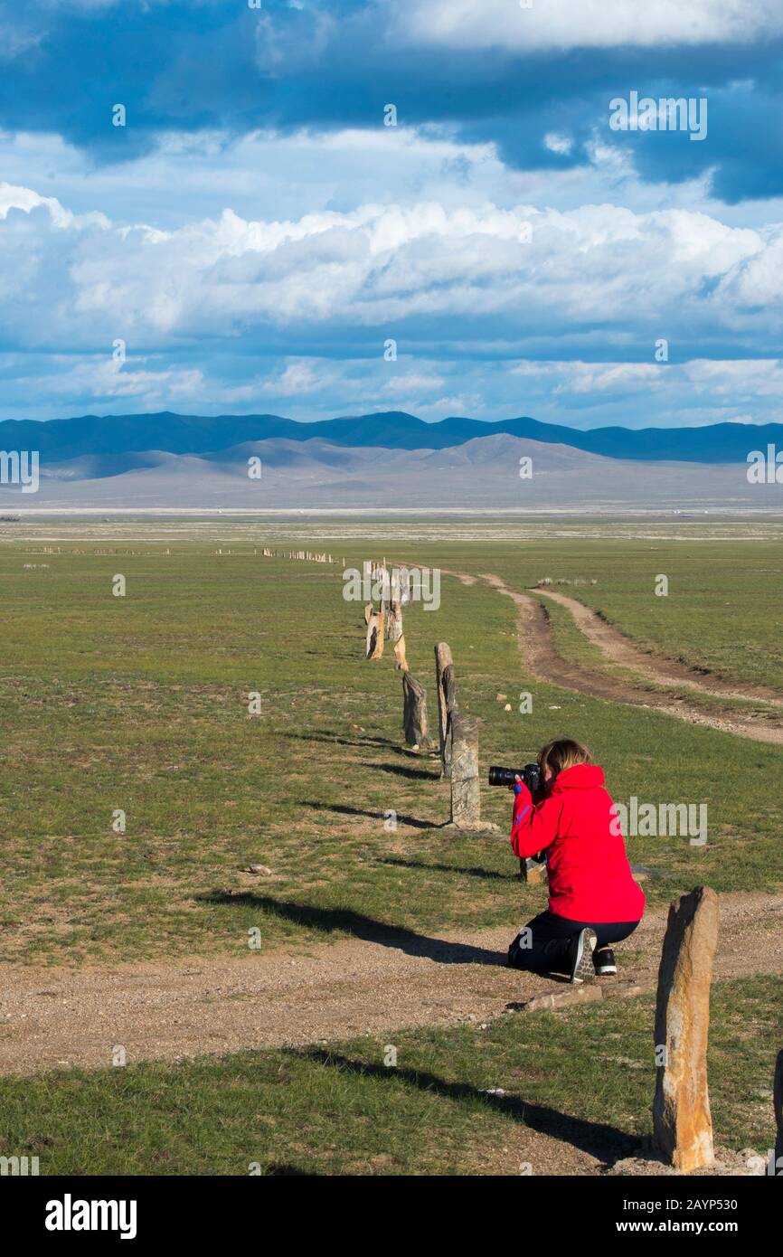 Un turista sta fotografando il complesso di Ungut, un complesso di monumento turkico costituito da pietre dell'uomo e numerose tombe dei secoli 6-8th ad a Hu Foto Stock