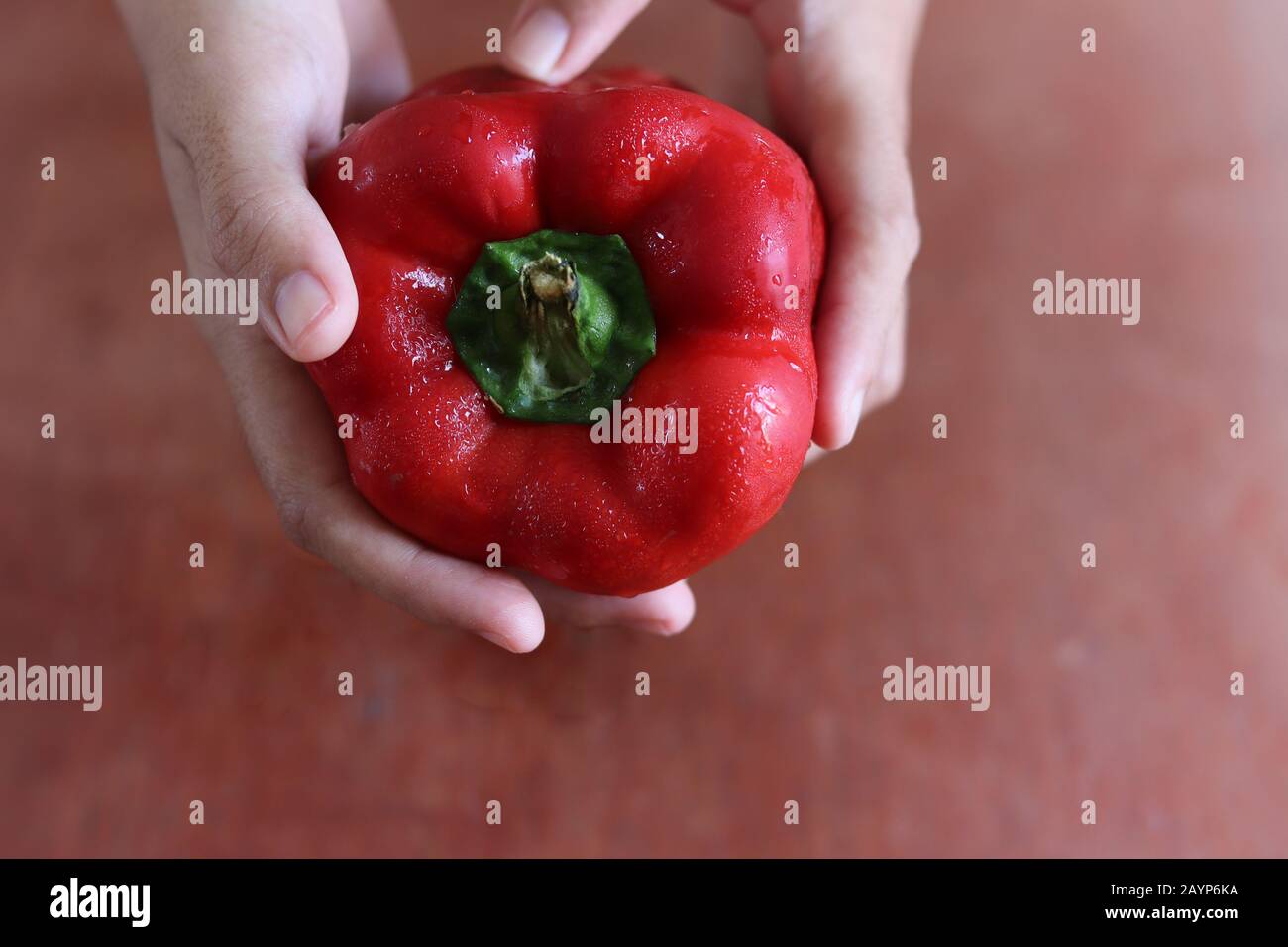 Peperone rosso su sfondo di legno scuro che mostra il concetto di cucina, cucina, stile di vita vegano e dieta a base di piante Foto Stock