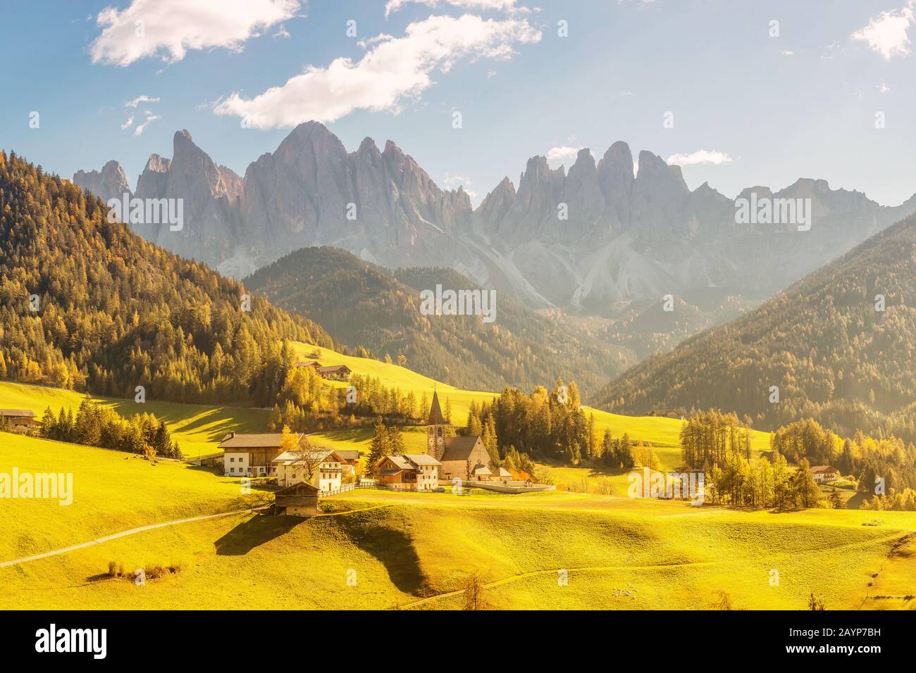 Famosa destinazione di viaggio nella valle delle Dolomiti Funes. Val di Funes e il villaggio di Santa Magdalena in autunno con le Alpi rocciose sullo sfondo Foto Stock