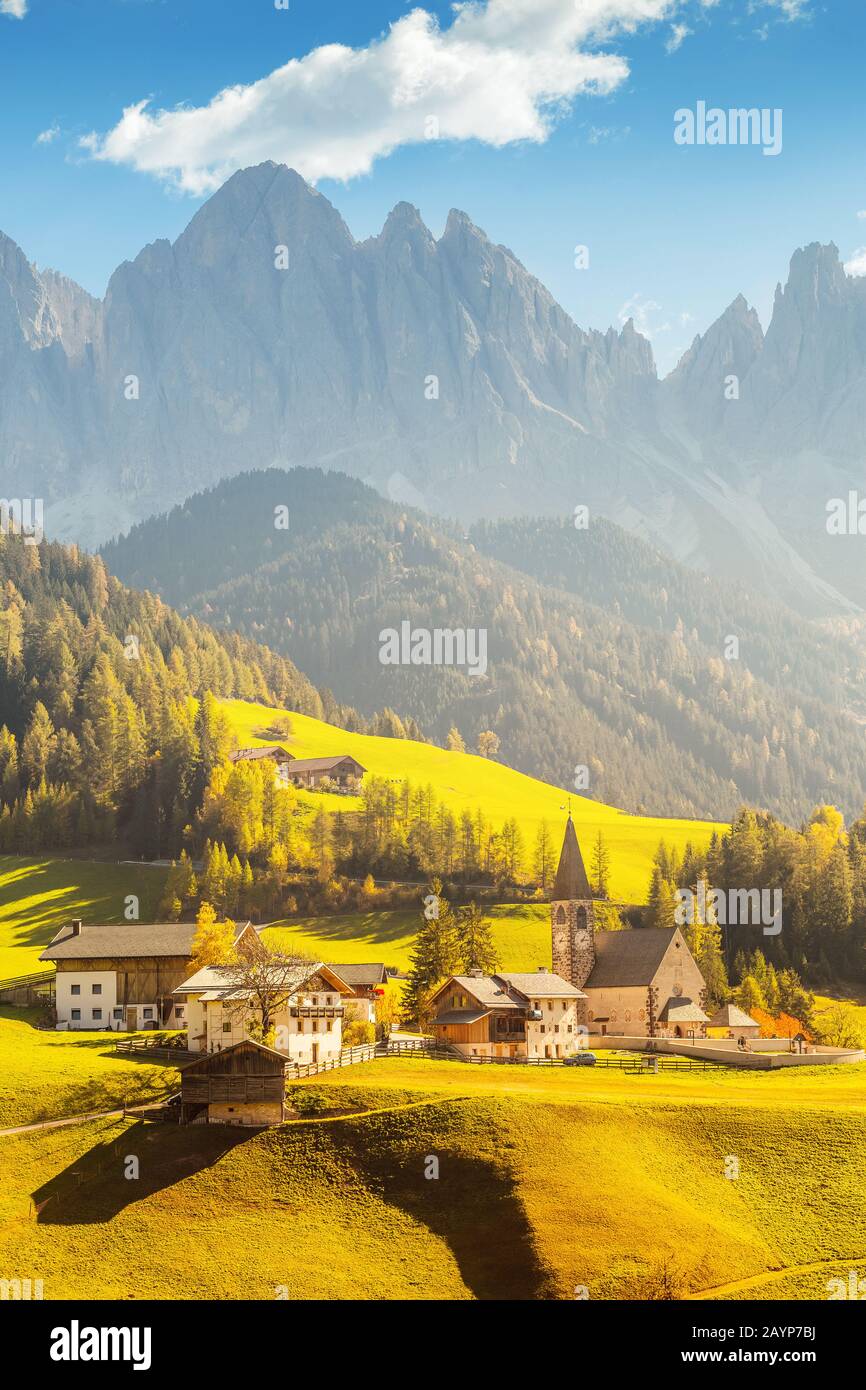Famosa destinazione di viaggio nella valle delle Dolomiti Funes. Val di Funes e il villaggio di Santa Magdalena in autunno con le Alpi rocciose sullo sfondo Foto Stock