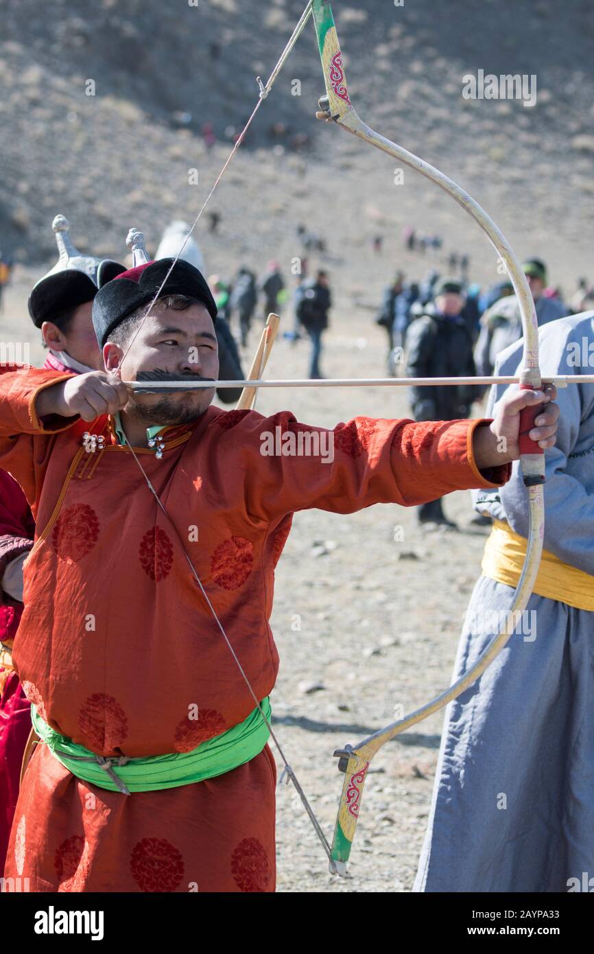 Arciere mongolo che mira durante il concorso di tiro con l'arco presso il Golden Eagle Festival Grounds vicino alla città di Ulgii (Ölgii) nella provincia di Bayan-Ulgii in Foto Stock