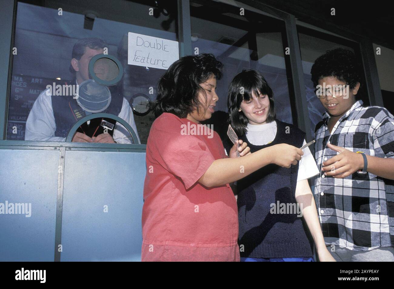 Studenti di otto anni che acquistano biglietti per il cinema. ©Bob Daemmrich Foto Stock