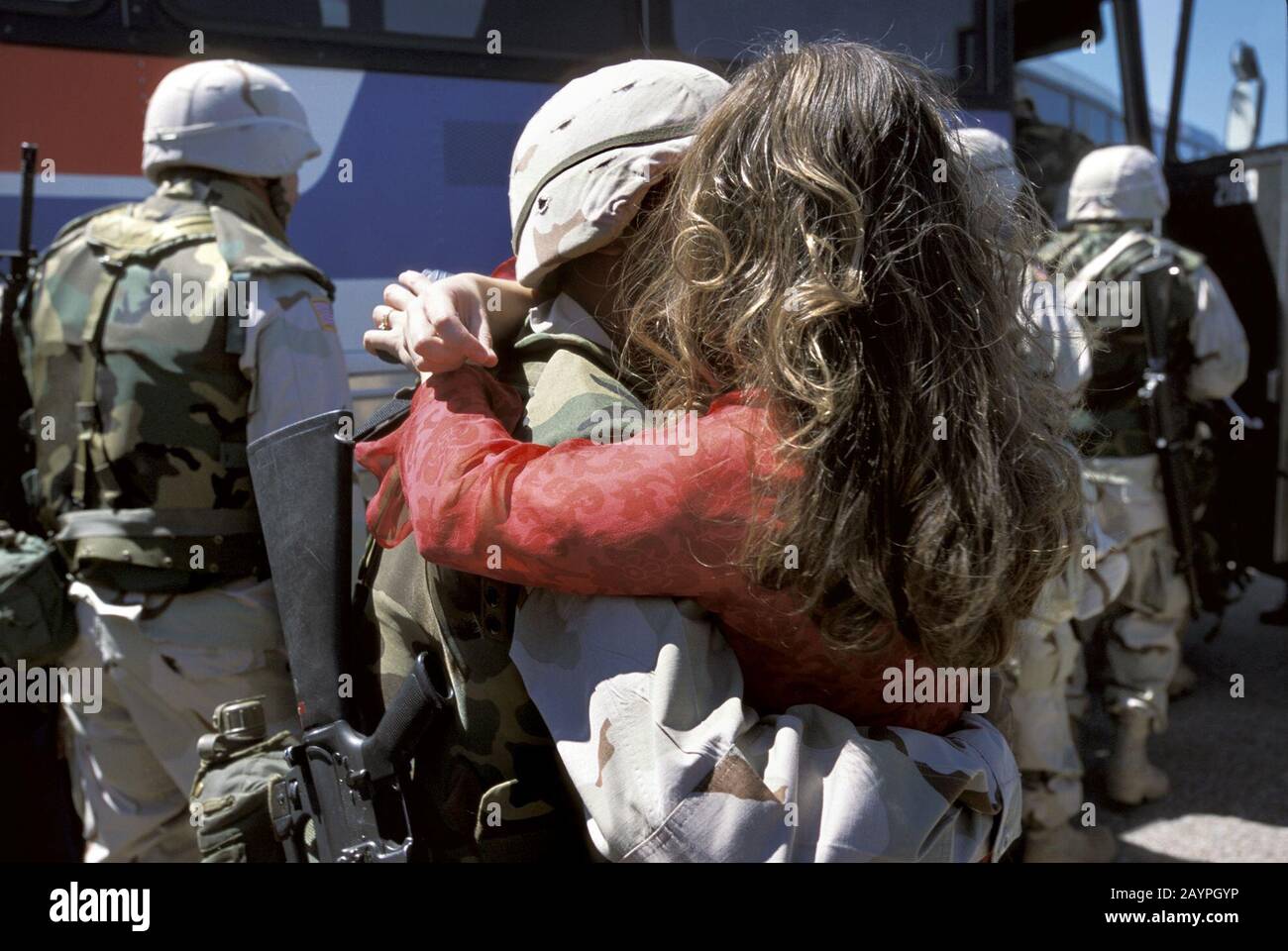 Fort Hood, Texas: Donna abbraccia soldato come truppe bordo autobus per lo spiegamento durante l'operazione libertà irachena, inverno 2003 ©Bob Daemmrich Foto Stock