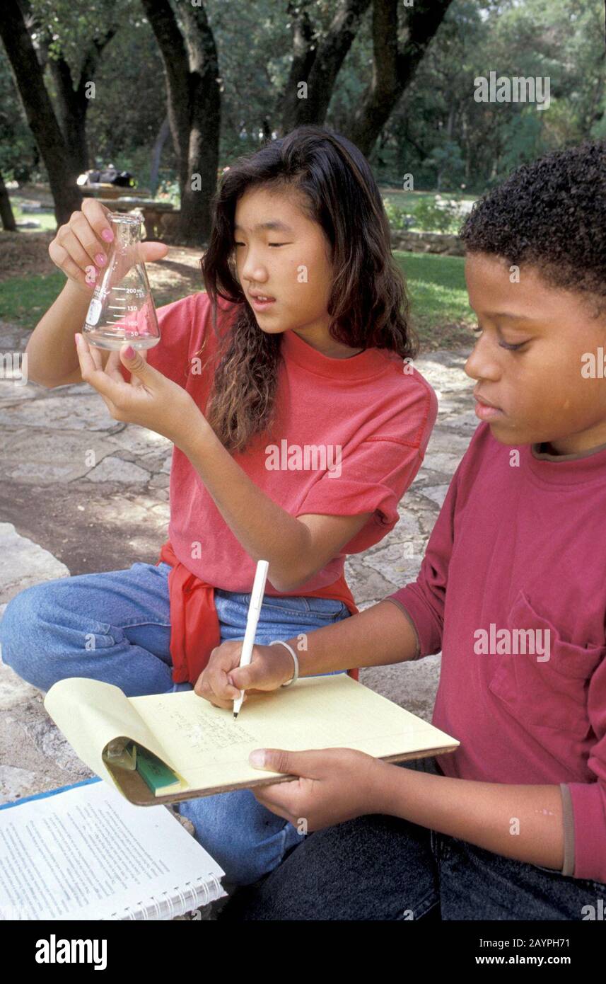 Austin, Texas USA: Gli studenti di settima classe prendono un campione d'acqua dal laghetto nel parco per un progetto di classe scientifica. ©Bob Daemmrich Foto Stock