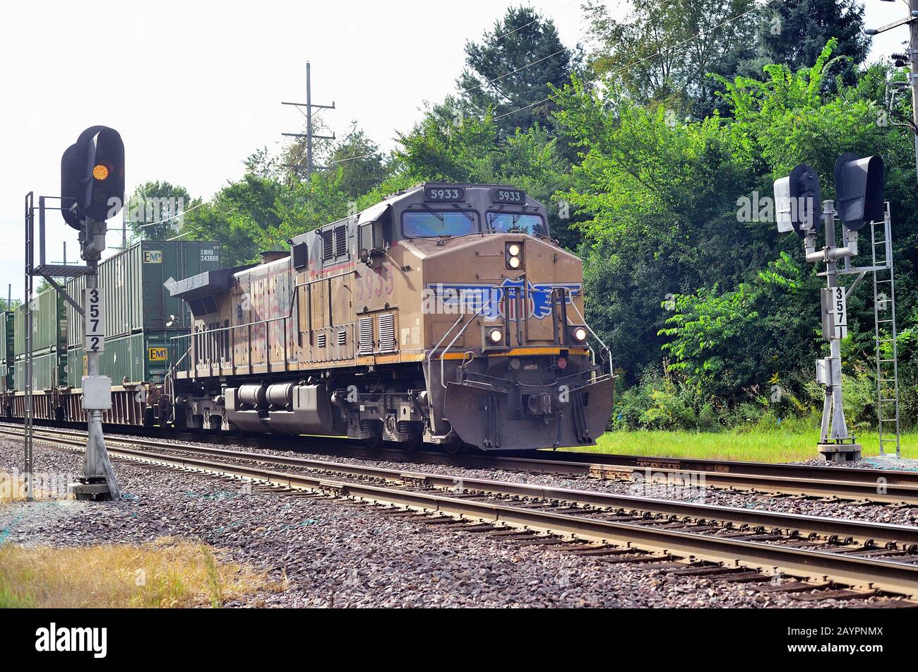 Elburn, Illinois, Stati Uniti. Locomotiva dell'Unione del Pacifico che conduce un treno merci intermodale oltre un segnale di blocco. Foto Stock