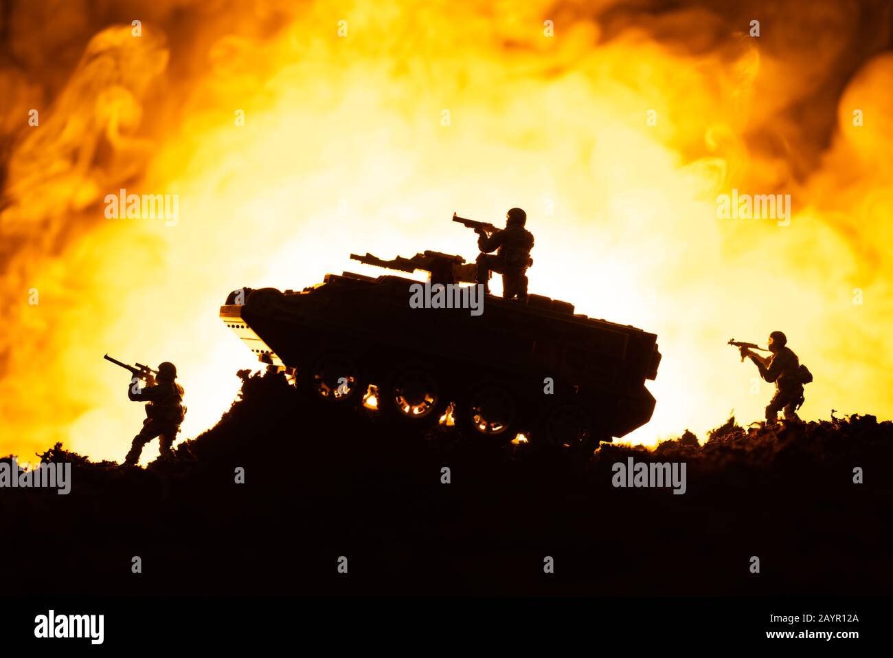 Scena di battaglia di tank giocattolo e soldati con fuoco sullo sfondo Foto Stock