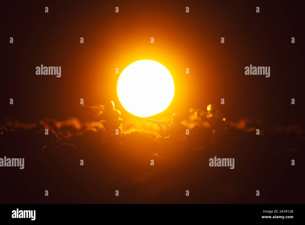 Scena di battaglia con soldati giocattolo e tramonto su sfondo nero Foto Stock