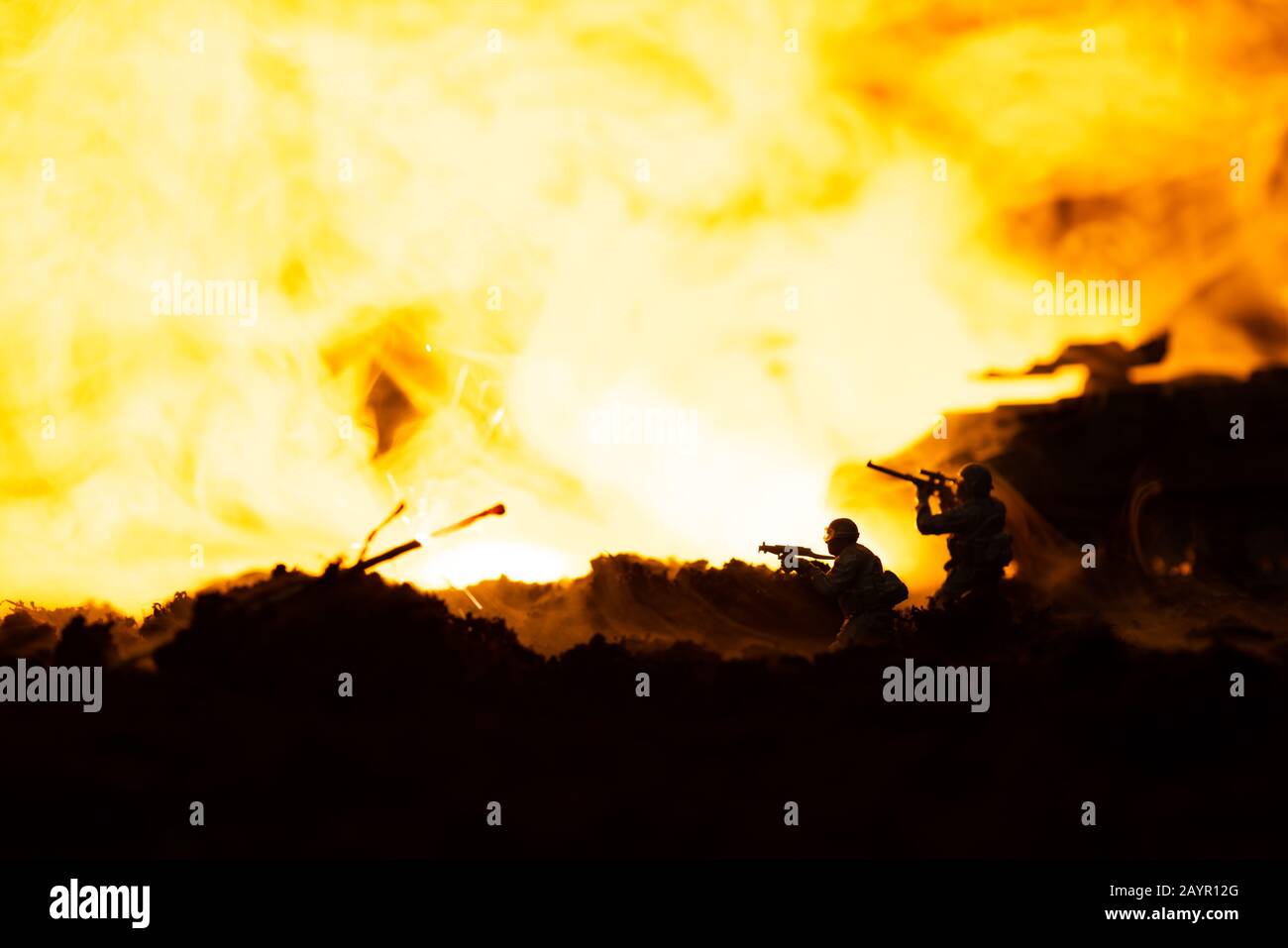 Scena di battaglia con soldati giocattolo e canotta sul campo di battaglia con fuoco sullo sfondo Foto Stock