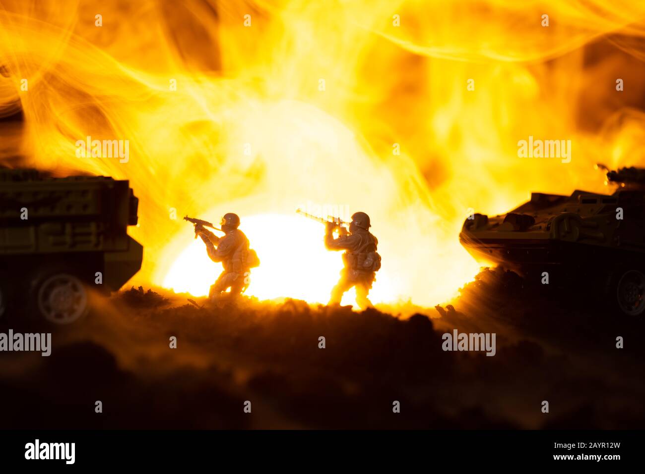 Silhouette di guerrieri giocattolo con carri armati in fuoco e tramonto sullo sfondo, scena di battaglia Foto Stock