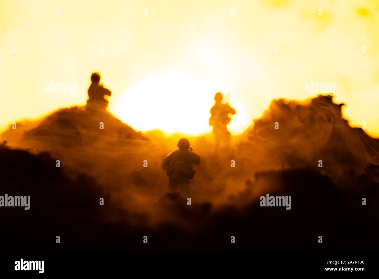 Fuoco selettivo dei guerrieri giocattolo sul campo di battaglia con tramonto sullo sfondo, scena di battaglia Foto Stock