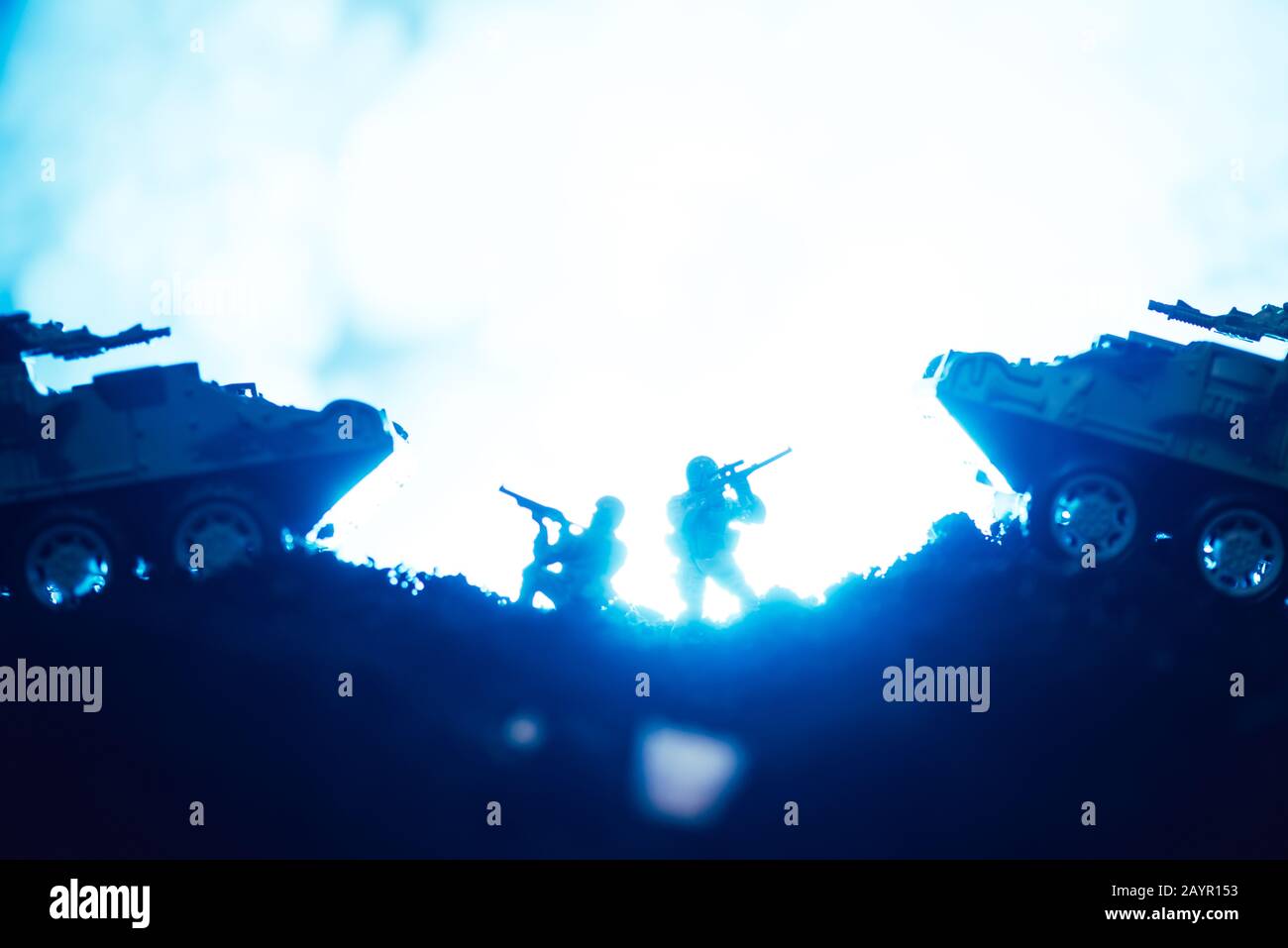 Scena di battaglia di guerrieri giocattolo e carri armati con fumo su sfondo blu Foto Stock