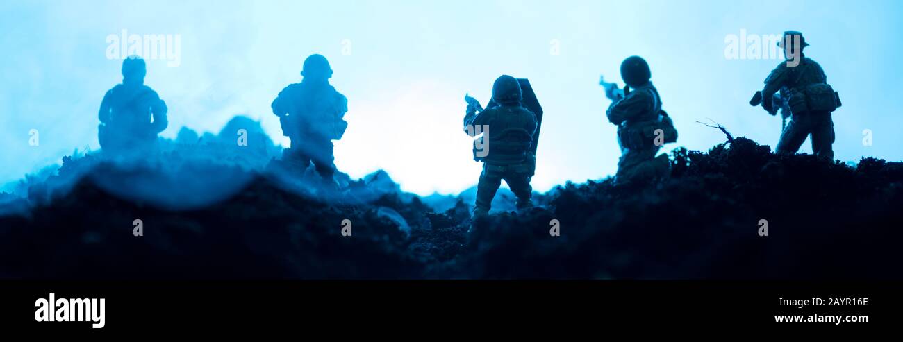 Scena di battaglia di soldati giocattolo con fumo su sfondo blu, colpo panoramico Foto Stock